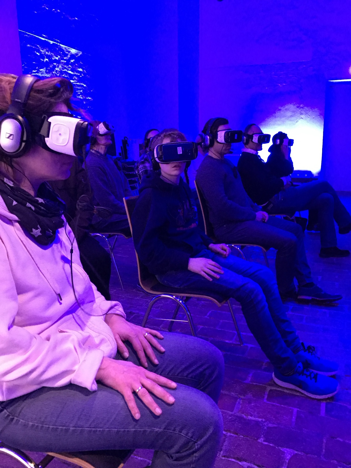 Gäste erleben gemeinsam einen VR-Film mit Headsets und Kopfhörern